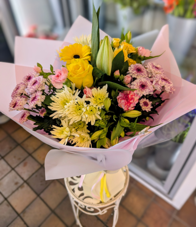 Colour Burst - handtied delivered locally or click and collect - A beautiful selection of seasonal flowers in summer tones, a handtied Bouquet, arranged in water. This will brighten someone's day. Locally Delivered Flintshire